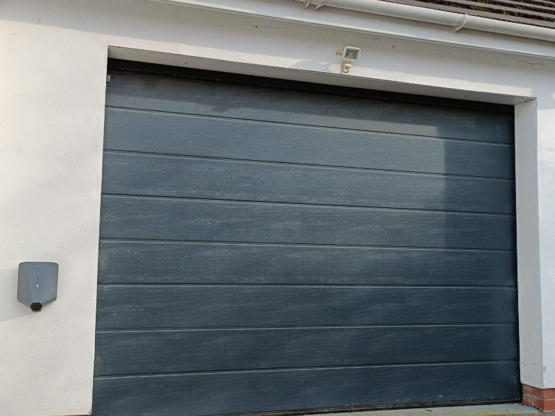 EV Charger install next to a grey garage door in in Bristol